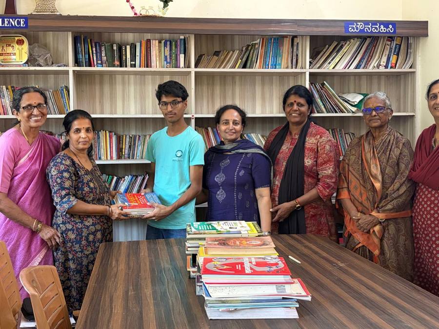 Vihaan handing over donated books at a community library, with shelves of books behind