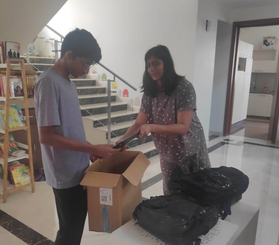 Vihaan collecting old electronics from a resident into a cardboard box